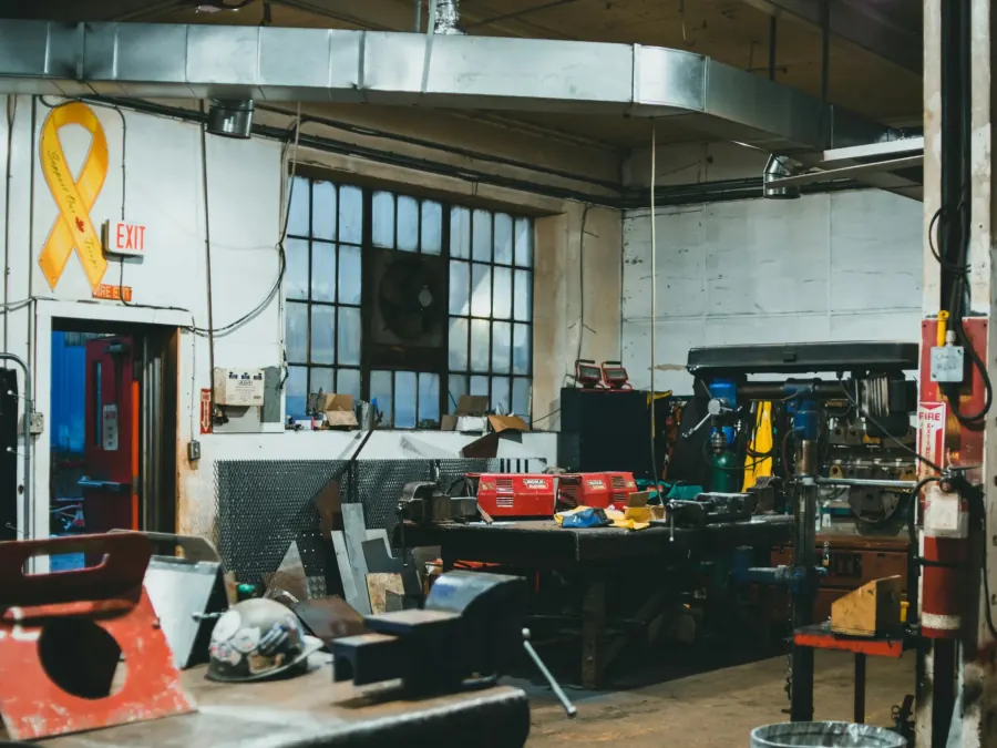A metal shop with machines and an exit door in frame.